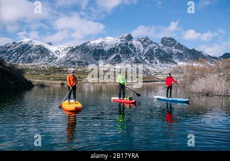 Three people stand up paddle surfing, Leon, Spain Stock Photo