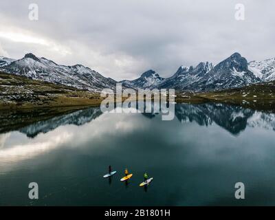 Aerial view of three people stand up paddle surfing, Leon, Spain