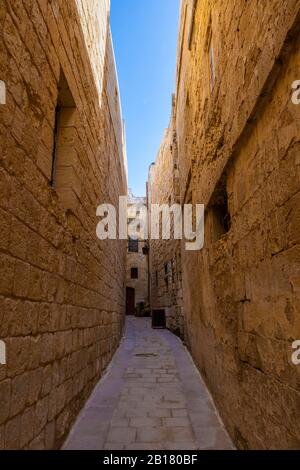 Malta, Mdina, Narrow cobbled street and medieval stone walls in old capital - Silent City Stock Photo