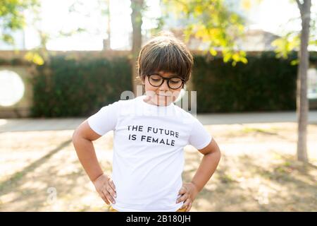 Proud little boy standing in the street with print on t-shirt, saying the future is female Stock Photo