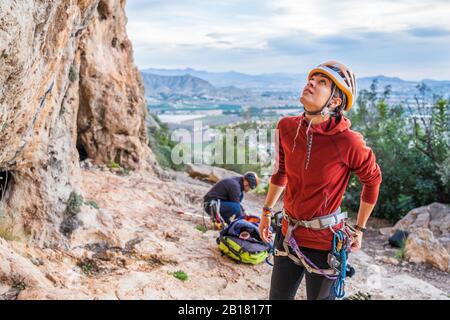 Female climber preparing looking up rock face Stock Photo