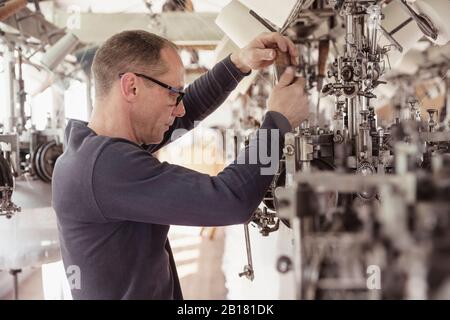 Man working at a machine in a textile factory Stock Photo