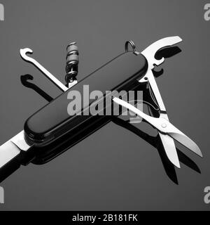 multipurpose folding knife on a black background. Swiss army knife Stock Photo