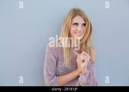 Portrait of smiling blond young woman wearing a knit jumper Stock Photo