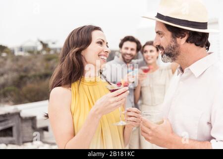 Couple and friends socializing on a cocktail party Stock Photo