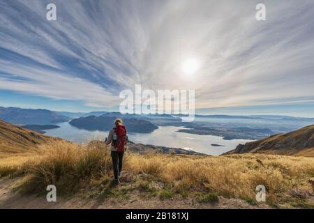 Woman hiking at Roys Peak, Lake Wanaka, New Zealand Stock Photo