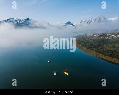 Aerial view of three people stand up paddle surfing, Leon, Spain Stock Photo