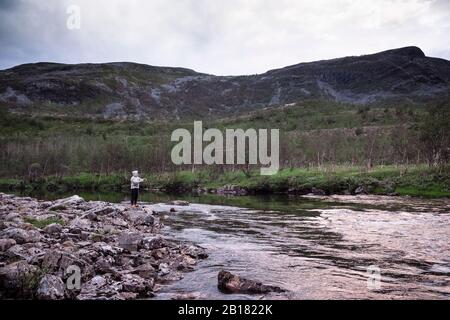 Fly fisherman fishing for salmons in river, Lakselv, Norway Stock Photo