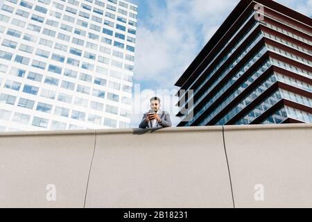 Casual young businessman using cell phone in the city Stock Photo