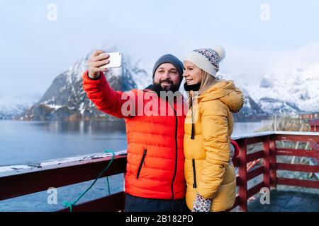 Tourist couple taking a selfie at Hamnoy, Lofoten, Norway Stock Photo