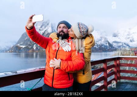 Tourist couple taking a selfie at Hamnoy, Lofoten, Norway Stock Photo
