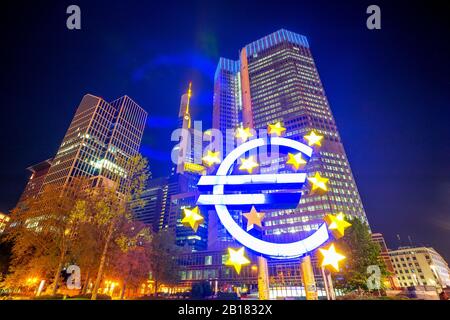 Germany, Hesse, Frankfurt, Low angle view of Euro-Skulptur in front of Eurotower at night Stock Photo
