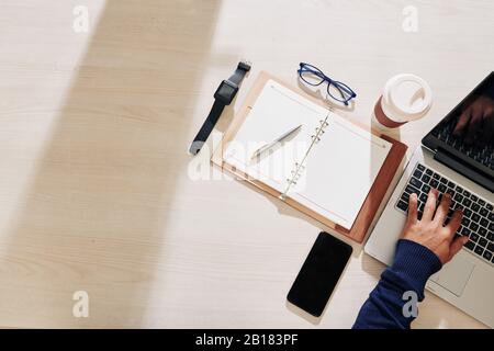 Opened planner, smartphone and laptop on desk of office manager, view from above Stock Photo