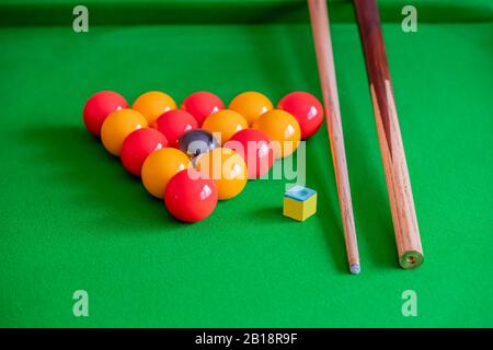26 Pool balls, cue chalk and wooden pool cue on the green felt of a pool table Stock Photo