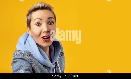 happy European girl with excessive energy close-up with a very happy expression on her face, opens her mouth in surprise. She is delighted with what Stock Photo