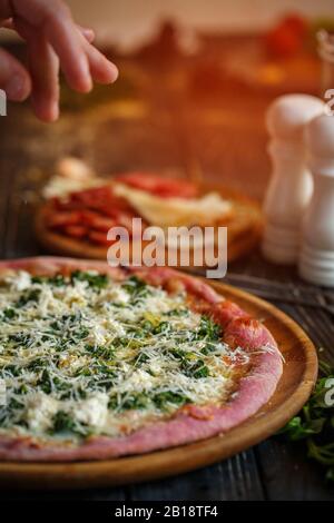 Chef's hand decorates a delicious hot pizza cheese. Stock Photo