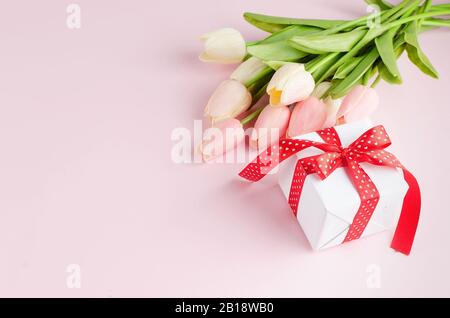 Gift box with bouquet of pink and white tulips on pastel pink background. Spring or holiday concept, March 8, International Women's Day, birthday. Cop Stock Photo