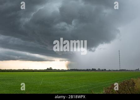 Fast moving thunderstorm over the green, wide open landscape of Holland Stock Photo