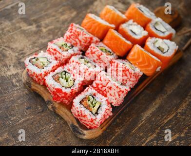 Set of two types of sushi. Sushi on brown wooden board and rustic style. Stock Photo