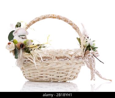 Natural wicker basket with flowers and ribbons. Isolated on a white background. Stock Photo