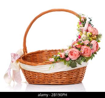 Brown wicker basket. Decor on one side of the basket handle with pink flowers and a small pink ceramic hare. Made for Easter. Stock Photo