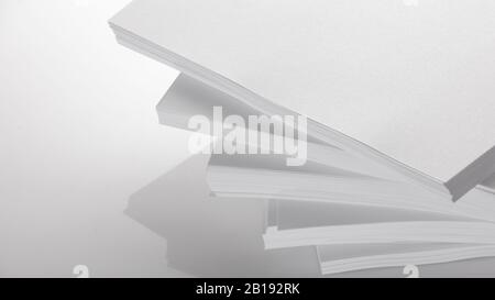 Abstract background, minimalism. Several stacks of white paper for photocopier, on a white background. Office work concept. Stock Photo