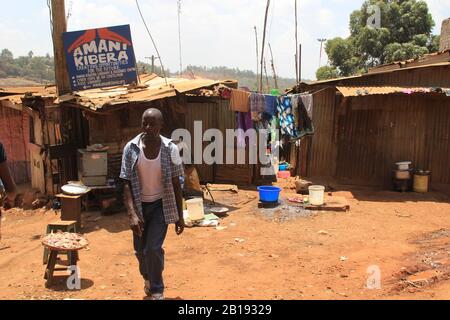 Kibera, Nairobi, Kenya - February 13, 2015: African poor man walks down the street near the huts Stock Photo