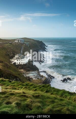 The large house known as Bakers Folly with the Lewinnick Lodge in the background on the rugged coast of Pentire Point East in Newquay in Cornwall. Stock Photo