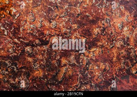 Rough dark grainy natural red brown sand stone texture background with scratches and uneven surface Stock Photo