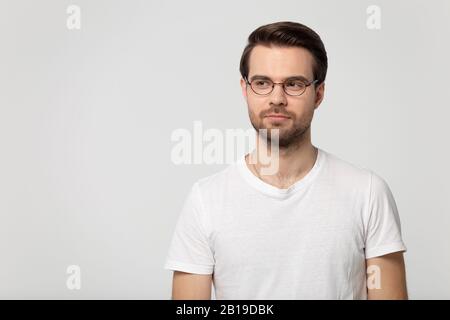 Thoughtful young confident man wearing eyeglasses standing aside copy space. Stock Photo