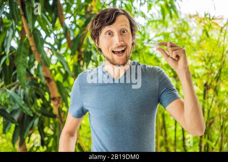 Man placing a bite plate in his mouth to protect his teeth at night from grinding caused by bruxism Stock Photo