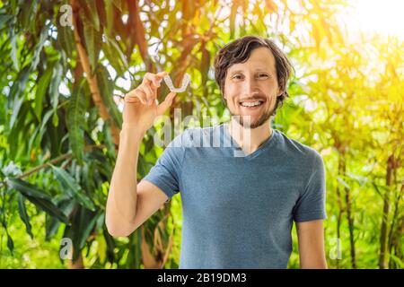 Man placing a bite plate in his mouth to protect his teeth at night from grinding caused by bruxism Stock Photo