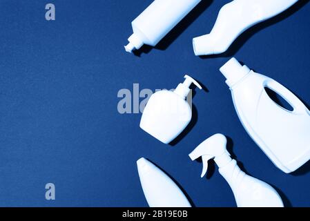 Cleaning products on classic blue background. Top view. Copy space. Chemical cleaning supplies. Stop plastic, recycling, separate collection of garbage concept. Stock Photo