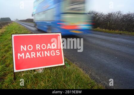 no road markings on road ahead warning sign after resurfacing leed yorkshire united kingdom Stock Photo