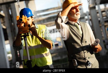Confident team of architects and engineers working together on construction site Stock Photo
