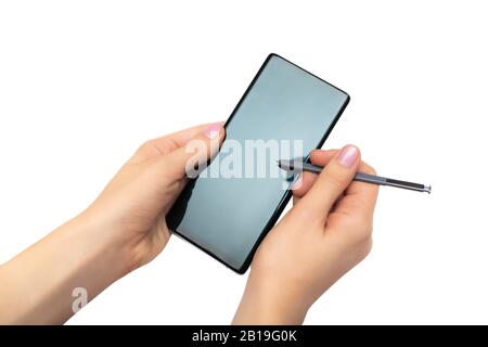 Female hands with cell phone with stylus on white background. Stock Photo