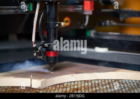 Computer cnc machine prent on wooden board in workshop, close-up Stock Photo