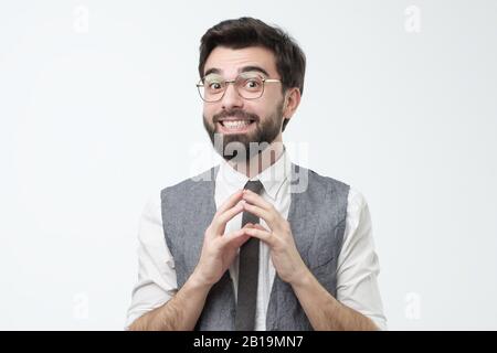 Shy young hispanic man asking for a favor or help smiling. Studio shot. Flatter or fawn concept Stock Photo