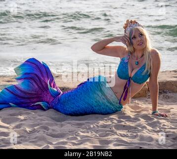 Blonde woman cosplay costume dressed as a mermaid posing on the sand at Bathers Beach Fremantle Western Australia. Stock Photo