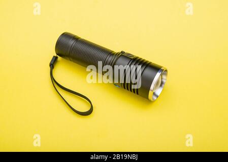 Battery powered flashlight on a yellow background with copy space Stock Photo