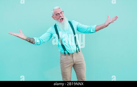 Crazy hipster man posing in front of the mcamera - Fashion tattoed guy having fun wearing trendy clothes - Joyful elderly lifestyle concept - Focus on Stock Photo