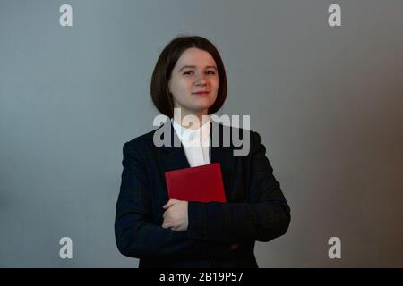 Young student woman holding notebook  looking over her goals. Confident successful woman looking in her notepad with her goals. Stock Photo