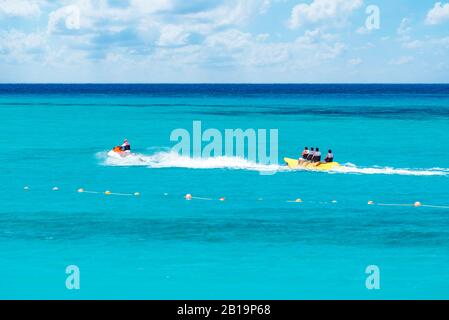 A Group of Happy People Riding Banana Boat Under Sunlight with Blue Sea Water in Background, Sharm El Sheikh, Sinai, Egypt Stock Photo