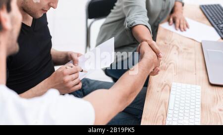 close up. handshake employee near the desktop. Stock Photo