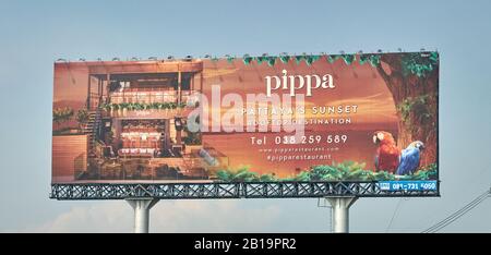 Large billboard advertising a restaurant by the ocean. Stock Photo