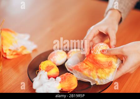 Preparing to Easter, Woman paint and color eggs with the help of napkins. Stock Photo