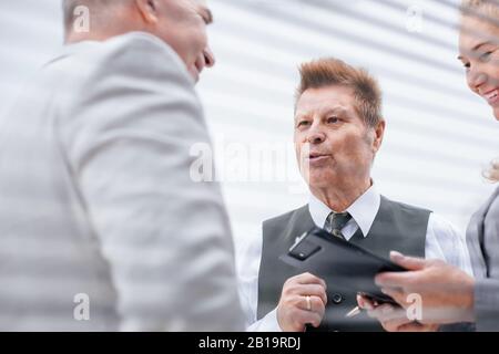 close up. a group of serious employees discuss something standing in the office. Stock Photo