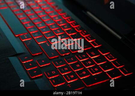 Closeup of a modern laptop computer keyboard keys. Soft lighting in red tones. Stock Photo
