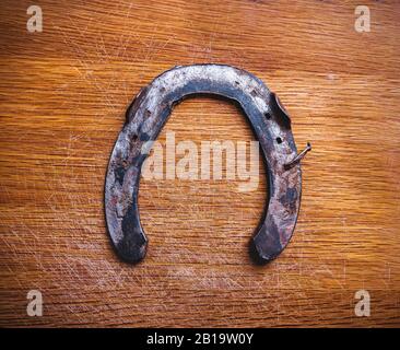 old rusty horseshoe on a wooden background Stock Photo