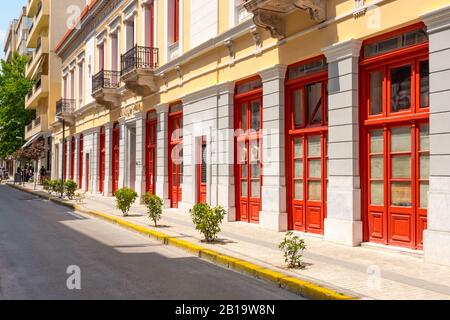 Modern bright street exterior. Greece, Europe. Modern architecture of europe. Empty european street. No people on the street. Building exterior in details. Narrow sidewalk with small plants Stock Photo